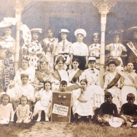 History Mystery Photo #1 The Heyworth Public Library holds in it's archive this picture of a group of youth we think dates back to 1920 - 1925? Some of the youth are wearing sashes with the names of Heyworth area businesses. We know this from our newspaper indexing project that is currently in progess in the same time period. The name Della Van Valey is inscribed on the back of the group photo. This picture will be on display at the library for anyone to come and get a better look. We would love to have more information about who is in this picture, where it was taken, and why it was taken?